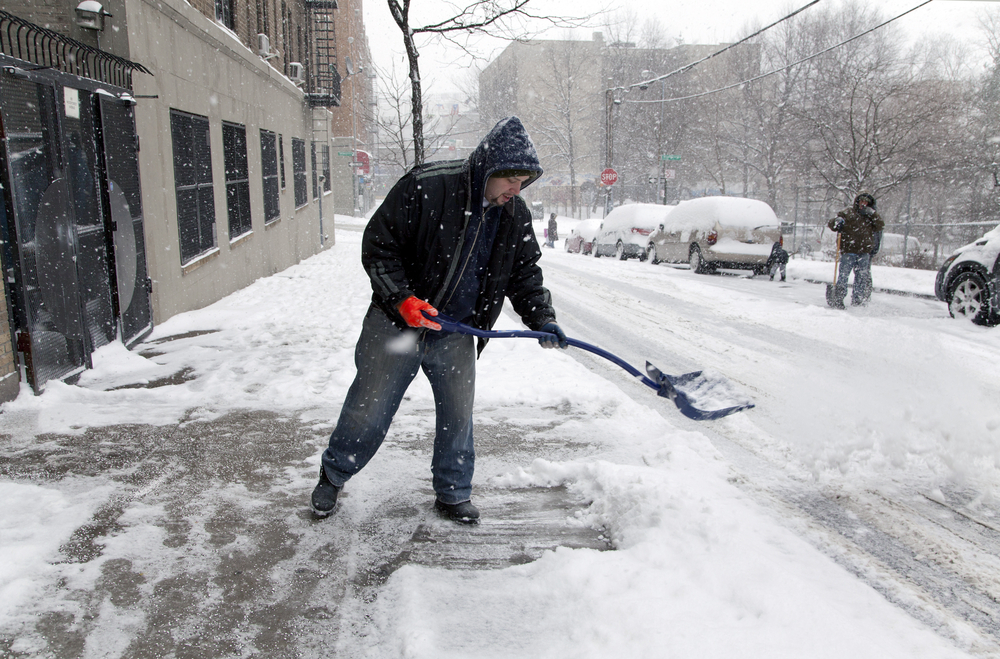 Uomo che spala la neve a New York (© Depositphotos)