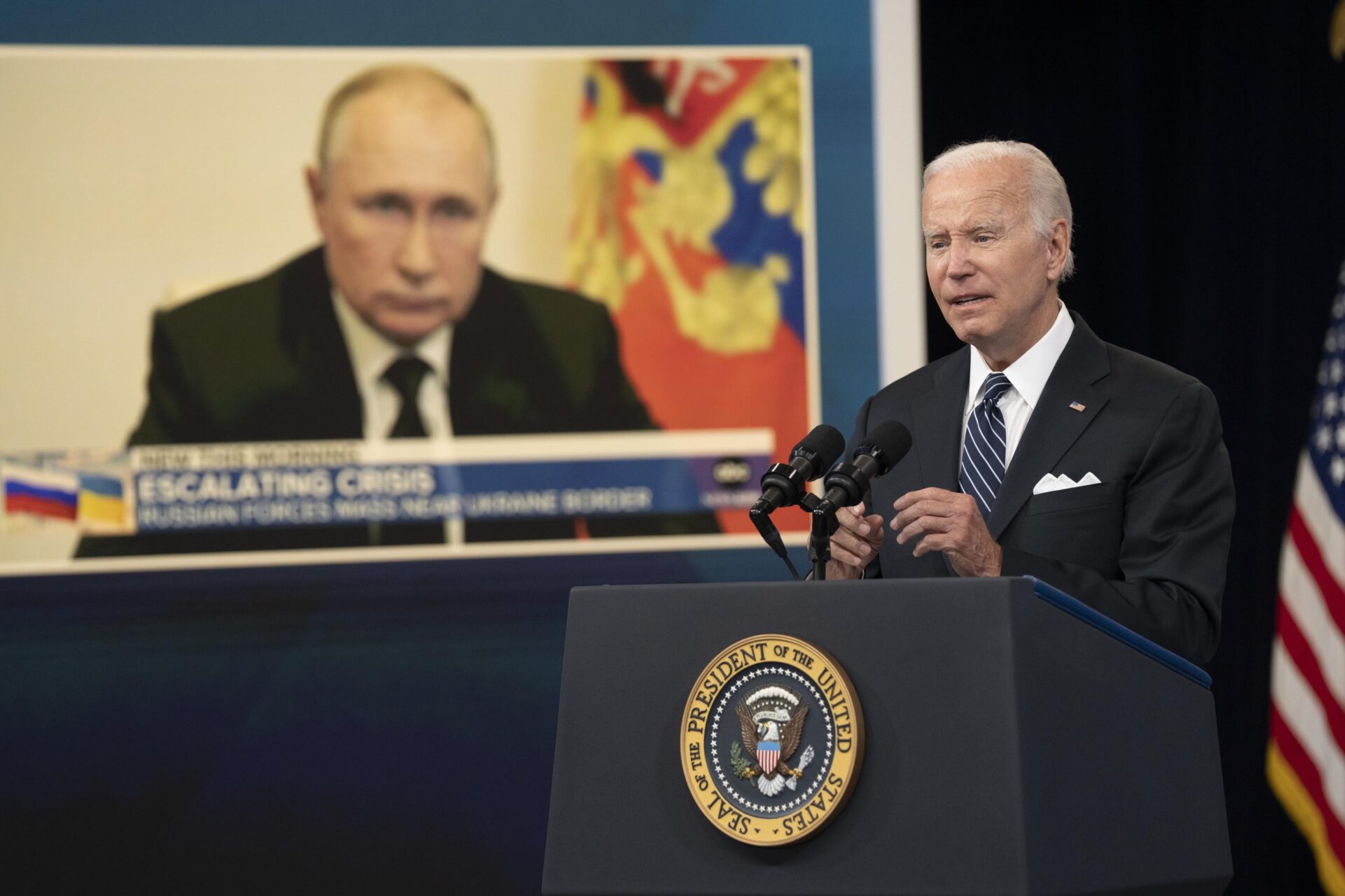 Il presidente degli Stati Uniti, Joe Biden. Sullo sfondo il presidente della Federazione russa, Vladimir Putin (© Ansa)