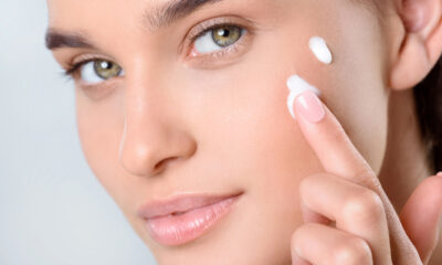 Donna che applica la crema viso