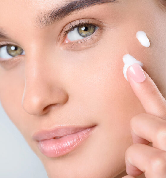 Donna che applica la crema viso