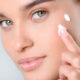 Donna che applica la crema viso