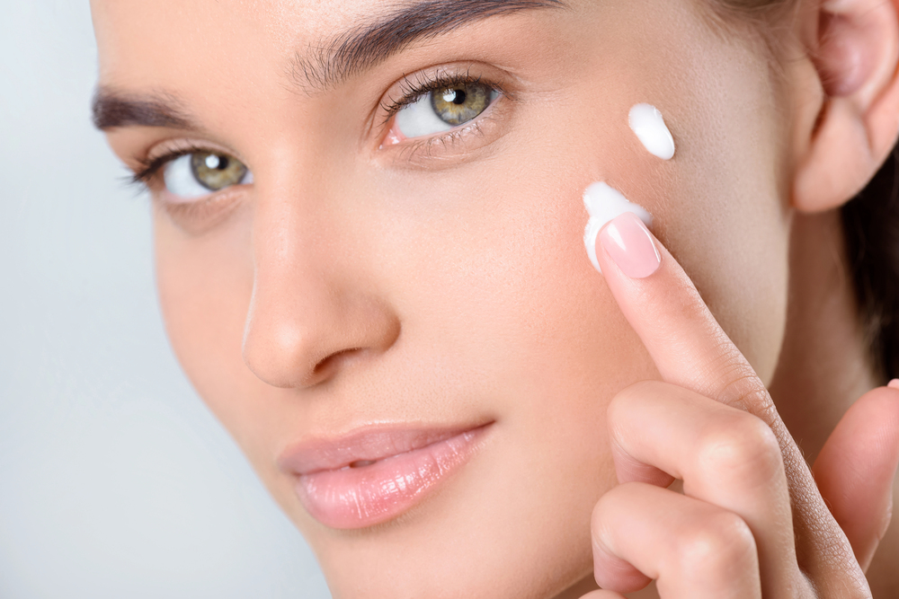 Donna che applica la crema viso