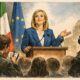 Giorgia Meloni durante una conferenza stampa a Palazzo Chigi, con bandiere italiana ed europea e giornalisti sullo sfondo