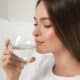Ragazza che beve un bicchiere di acqua