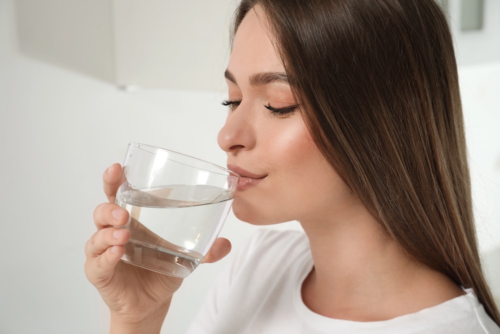 Ragazza che beve un bicchiere di acqua
