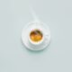 Cup of fresh made steaming coffee served in cup on blue background. Coffee background.
