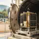 Illustrazione di un satellite compatto all’interno di una camera termovuoto in un ambiente industriale pulito.