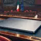 Un computer portatile chiuso su un banco, con l’aula della Camera sullo sfondo.