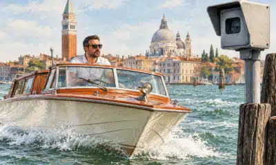 Un’imbarcazione a motore naviga nella laguna veneziana; un dispositivo di rilevamento della velocità è accennato in primo piano.