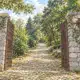 Illustrazione dell’ingresso in pietra aperto del Brich di Zumaglia e della strada ciottolata che sale nel bosco.