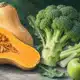 Illustrazione di una zucca aperta con buccia e semi visibili accanto a un broccolo con gambo e cimette distinguibili.