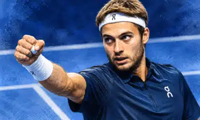 Illustrazione editoriale di un tennista ispirato alla foto di riferimento, in primo piano con il pugno alzato davanti a uno sfondo blu.