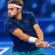 Ritratto illustrato di un tennista con maglia blu e racchetta, sullo sfondo sfumato di un campo indoor.
