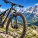 Una mountain bike ferma su un sentiero alpino, con montagne sullo sfondo.