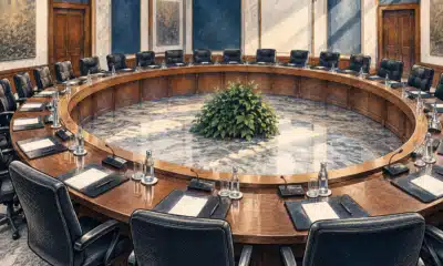 Illustrazione editoriale di un tavolo consiliare curvo e vuoto in una sala istituzionale essenziale.