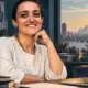 Illustrazione editoriale di Lina Attalah in una redazione, accanto a un documento senza scritte e a un computer.