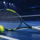 Una racchetta da tennis in primo piano davanti a un campo indoor vuoto, in un’illustrazione sul ritiro di Arthur Fils.