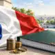 Drapeau francese accanto a un dossier di bilancio senza scritte e a poche monete.
