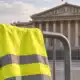 La facciata dell’Assemblea nazionale francese accanto a un gilet giallo