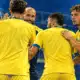 Giocatori del Frosinone in maglia gialla raccolti in una celebrazione di squadra.