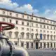 Illustrazione editoriale di Palazzo Chigi con una valvola del gas chiusa in primo piano.