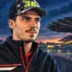 Illustrazione editoriale di un pilota ispirato alla foto di riferimento, davanti a uno sfondo essenziale che richiama il circuito di Sepang.