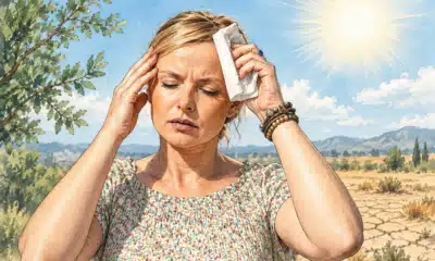 Illustrazione di una donna adulta che tiene un panno chiaro alla tempia in una giornata calda.