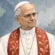 Ritratto editoriale del Papa, in abito bianco con un accento rosso, su sfondo sobrio.