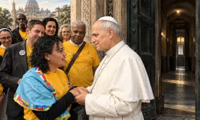 Un libro di preghiera presso la soglia socchiusa di un ingresso istituzionale, simbolo delle visite pastorali temporanee a Broadview.