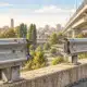 Illustrazione di un tratto di guardrail con un’apertura su un cavalcavia urbano, senza veicoli o persone.