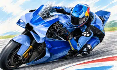 Illustrazione di un pilota con casco e tuta blu su una moto blu inclinata in curva.