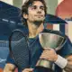 Ritratto illustrato di Musetti con racchetta, coppa simbolica e campo indoor sullo sfondo