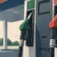 Erogatore di carburante con pistola inserita in un’automobile presso una stazione di servizio