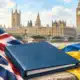 Un fascicolo blu senza scritte accanto ai colori delle bandiere britannica e ucraina, con Westminster sullo sfondo.