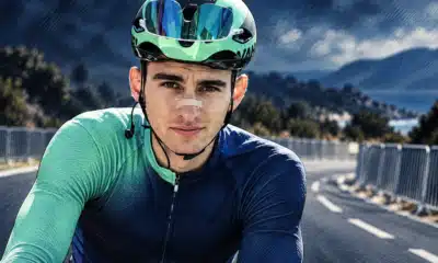 Illustrazione editoriale di un ciclista ispirato alla foto di riferimento, con una barriera da gara sullo sfondo.