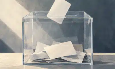 Illustrazione di un’urna elettorale trasparente con alcune schede al suo interno.