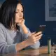 Illustrazione di una donna adulta accanto a uno smartphone e a un kit generico per sigaretta elettronica.