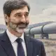 Ritratto illustrato del soggetto della foto di riferimento davanti a un tratto di oleodotto.