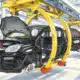 Illustrazione di un’automobile senza marchi in fase di assemblaggio su una linea industriale.