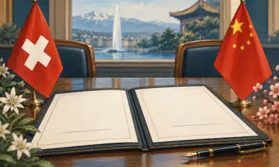 Illustrazione di un fascicolo diplomatico aperto con lo spazio per la firma ancora vuoto e richiami cromatici alle bandiere svizzera e cinese.
