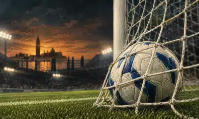 Un pallone fermo nella rete di una porta da calcio, illustrato su uno sfondo scuro di campo.